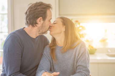 Romantik orta yaş çift birlikte oturan ve evde öpüşme