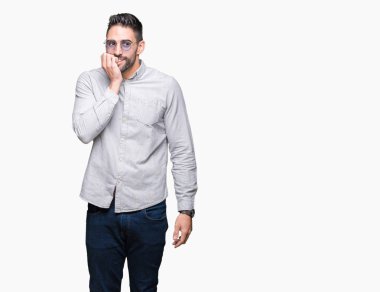 Genç yakışıklı adam stresli ve gergin ile izole arka plan üzerinde güneş gözlüğü takıyor tırnak ısırma dudaklarından eller. Anksiyete sorunu.