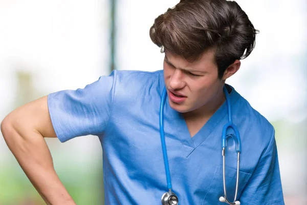 年轻的医生穿着医疗制服在孤立的背景下背痛 用手触摸背部 肌肉疼痛 — 图库照片