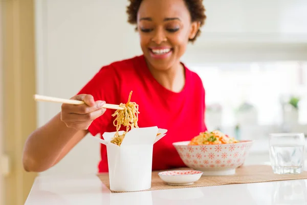 Gyönyörű fiatal afrikai-amerikai nő étkezési tésztával choo segítségével — Stock Fotó