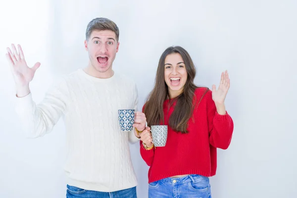 Casal Jovem Bonito Sobre Fundo Isolado Branco Bebendo Uma Xícara — Fotografia de Stock