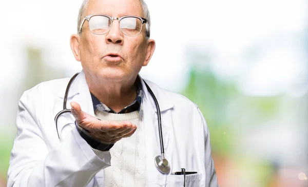 Guapo Médico Senior Hombre Con Abrigo Médico Mirando Cámara Soplando — Foto de Stock