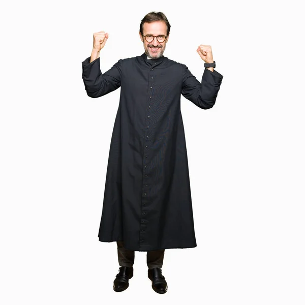中年牧师男子穿着天主教长袍显示手臂肌肉微笑自豪 健身理念 — 图库照片