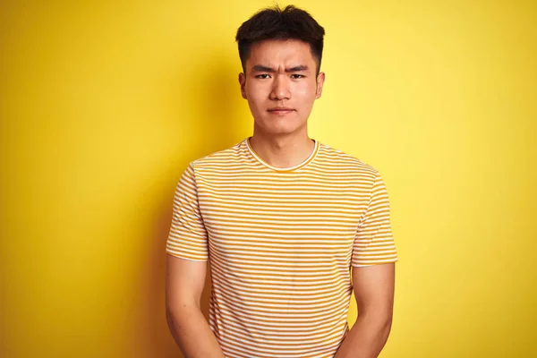 孤立した黄色の背景の上に立つTシャツを着たアジアの若い中国人男性は 落ち込んで苦しみを心配し 怒りと恐怖を叫びました 悲しい表現 — ストック写真