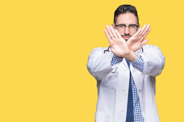 Handsome young doctor man over isolated background Rejection expression crossing arms and palms doing negative sign, angry face