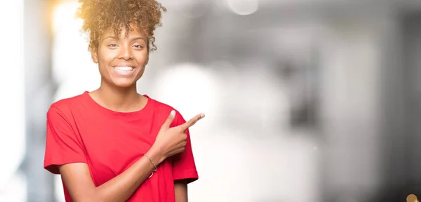 美丽的年轻非洲裔美国女人在孤立的背景欢快的笑容与手和手指指向的一侧 愉快和自然的表情在脸上 — 图库照片