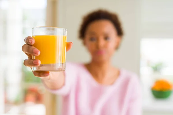 年轻的非洲裔美国妇女在家里喝橙汁 聪明的脸上自信的表情思考认真 — 图库照片