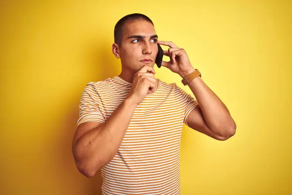 Νέος Όμορφος Άνθρωπος Μιλάει Χρησιμοποιώντας Smartphone Πάνω Από Κίτρινο Απομονωμένο — Φωτογραφία Αρχείου