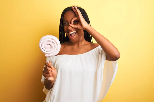 Joven Mujer Afroamericana Comiendo Caramelos Pie Sobre Fondo Amarillo Aislado — Foto de Stock