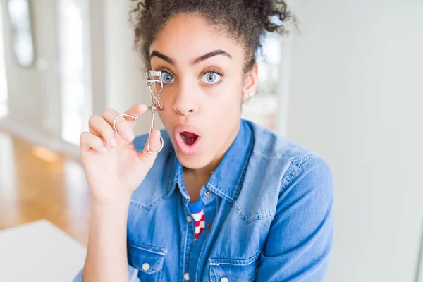 年轻的非洲美国女孩使用睫毛卷发器害怕在震惊与惊喜的脸 害怕和兴奋与恐惧的表情 — 图库照片