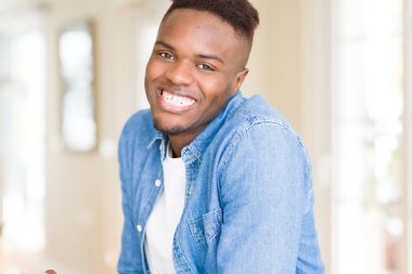 Gülümseyen yüzünde kocaman bir gülümseme ile neşeli Afrika yakışıklı genç