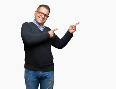Orta yaş bussines Arap adam gözlük gülümseyen ve iki elleri ve parmakları ile tarafına işaret kamera bakarak izole arka plan üzerinde.