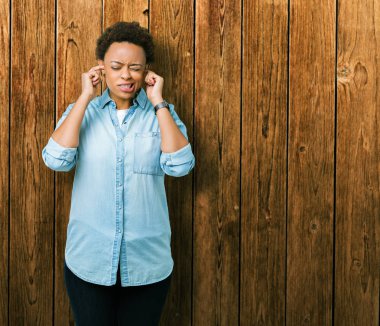 Genç güzel Afrikalı-Amerikalı kadın parmakları ile yüksek sesle müzik gürültü rahatsız ifade kulaklarıyla kapsayan izole arka plan yüzünden. Sağır kavramı.