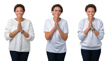 Birlikte emin gülümseyen bağışlanmak ellerle dua izole arka plan üzerinde afro saçlı genç Afro-Amerikan kadın.