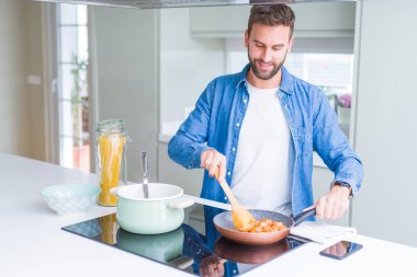 Evde makarna pişiren yakışıklı adam.