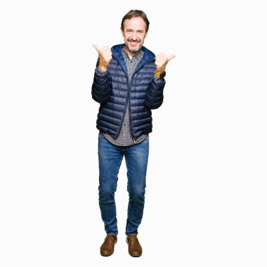 Orta yaş yakışıklı adam, el ile olumlu jest yapıyor kış ceket başarı işareti giyen, gülümseyen ve mutlu kadar başparmak. Neşeli ifade ile kamera bakarak, kazanan jest.