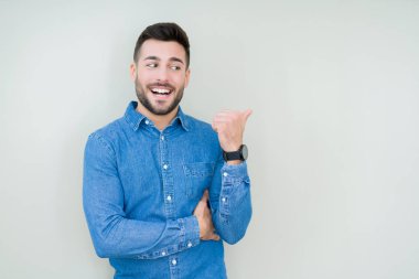 Yakışıklı delikanlı arıyor ve başparmak yanında yukarıyı mutlu yüz ile gülümseyen izole arka plan üzerinde.
