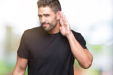 Yakışıklı delikanlı bir işitme söylenti ya da dedikodu için dinleme kulak üzerinde el ile gülümseyen izole arka plan üzerinde. Sağırlık kavramı.