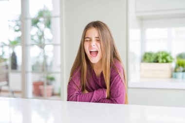 Beyaz masada güzel genç kız çocuk mide üzerine el ile çünkü hazımsızlık, ağrılı hastalık rahatsızlık hissi. Ağrı kavramı.