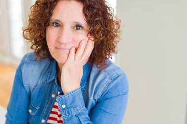 Güzel yaşlı kadın düşünme yorgun görünümlü ve çapraz kolları ile depresyon sorunları ile sıkılmış.