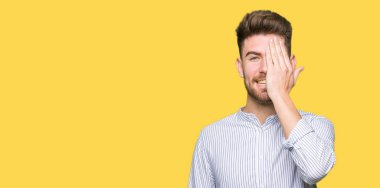 Yakışıklı delikanlı yüz ve sürpriz duygu kendinden emin gülümseme ile el ile bir göz kapsayan.