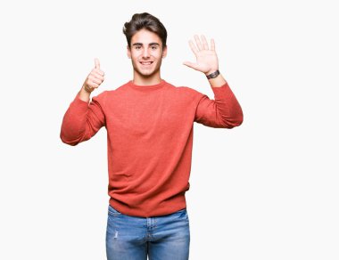 Yakışıklı delikanlı gösterilen ve parmakları ile işaret izole arka plan üzerinde kendinden emin ve mutlu gülümseyerek süre 6 numara.