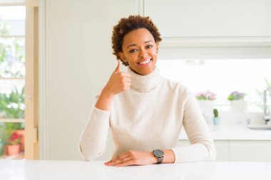 Genç güzel Afrikalı-Amerikalı kadın evde mutlu Yaşasın el hareketini yapıyor. Kameraya bakarak başarı gösteren ile ifade onaylama.