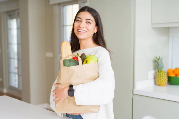 Hermosa Joven Sonriendo Sosteniendo Una Bolsa Papel Llena Comestibles Cocina —  Fotos de Stock