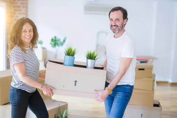 Seniorenpaar mittleren Alters zieht in ein neues Haus und hält Pappkarton — Stockfoto
