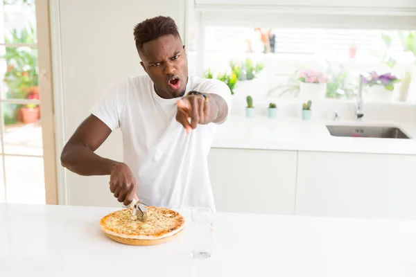 Africano Americano Comendo Pizza Queijo Casa Apontando Com Dedo Para — Fotografia de Stock