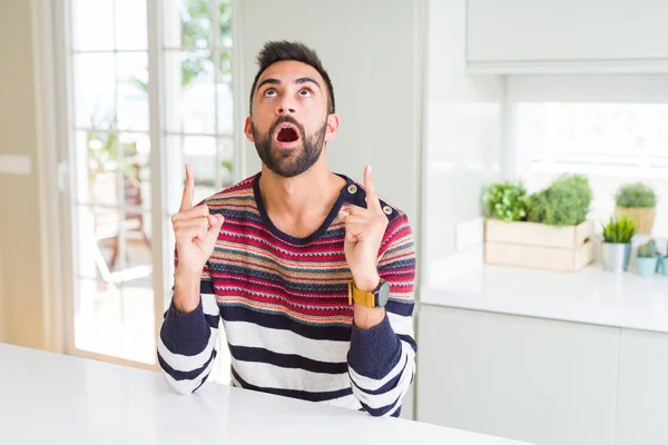 Bonito Homem Hispânico Vestindo Listras Camisola Casa Espantado Surpreso Olhando — Fotografia de Stock