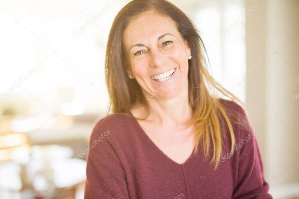 Beautiful middle age woman smiling at home