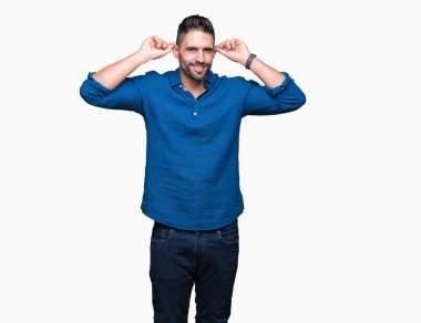 İzole arka plan gülen çekerek kulakları parmaklar, komik jest ile genç yakışıklı adam. Seçmelere sorun