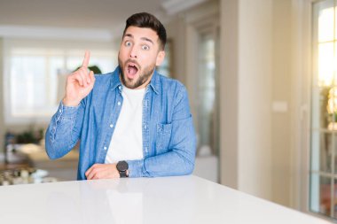 Evde Genç yakışıklı adam başarılı bir fikir ile parmak yukarı işaret. Çıkıldı ve mutlu. Bir numara.