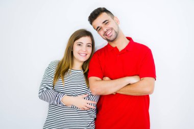 Beyaz izole arka plan üzerinde birlikte genç güzel çift fotoğraf makinesi bakıyor çapraz silah ile gülümseyen yüz. Pozitif kişi.