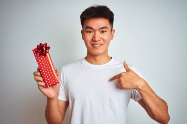 Genç Asya Chinese adam tutan Sevgiliye mevcut Standing üzerinde izole beyaz arka plan ile sürpriz yüz işaret parmak için kendisi