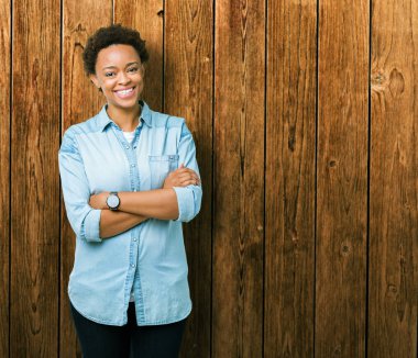 İzole arka plan mutlu yüz çapraz silah kameraya bakarak ile gülümseyen genç güzel Afrikalı-Amerikalı kadın. Olumlu bir kişi.