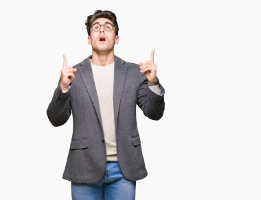 İzole arka plan üzerinde gözlüklü genç iş adamı şaşırtmak ve yukarıya bakıp parmakları ile işaret şaşırttı ve silah kaldırdı.