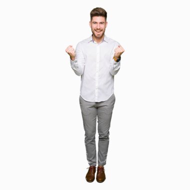 Genç yakışıklı iş adamı kutluyor şaşırttı ve başarı için kaldırdı kollarını açarak hayret ve gözleri açık. Kazanan kavramı.