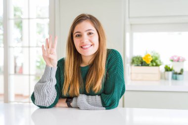 Genç güzel artı boyutu kadın rahat çizgili kazak gösteren giyen ve emin ve mutlu gülümserken parmakları ile dört numara işaret.