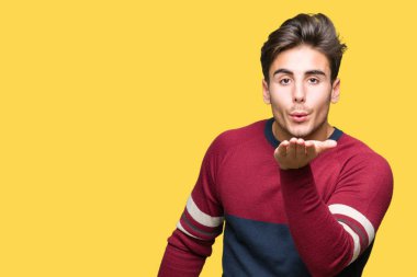 Yakışıklı delikanlı bir öpücük el ile güzel ve seksi olmak hava üfleme kamera bakarak izole arka plan üzerinde. Aşk ifade.
