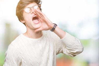 Bağırarak ve ağzı üzerinde el ile yan için çığlık izole arka plan üzerinde gözlük takan yakışıklı delikanlı. İletişim kavramı.