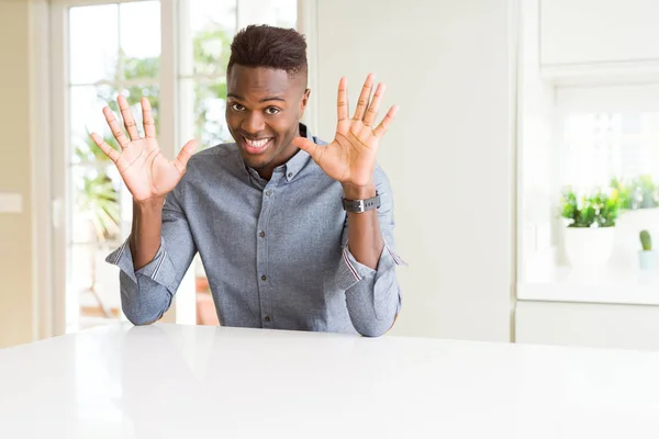 白いテーブル表示と指で上向きにハンサムなアフリカ系アメリカ人数 自信を持って 幸せな笑みを浮かべて — ストック写真
