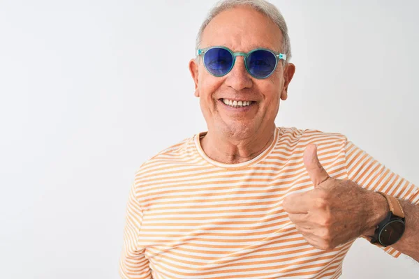 穿着条纹T恤和太阳镜的白发老人在孤立的白色背景上 用手竖起大拇指 做着快乐的手势 批准表达式 以显示成功的相机 — 图库照片