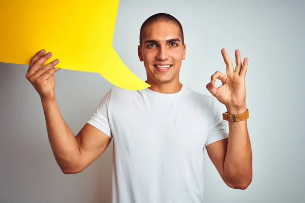 Jonge Man Holding Gele Toespraak Bubble Witte Geïsoleerde Achtergrond Doen — Stockfoto