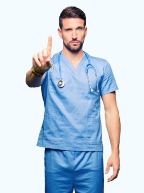 Yakışıklı Doktor adam tıbbi üniforma izole üzerinde arka plan işaret parmağını ve kızgın ifade ile