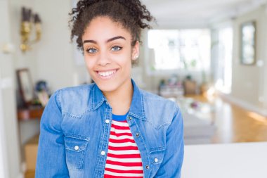 Yüzünde mutlu ve güzel bir gülümseme ile rahat denim ceket giyen afro saçlı güzel genç Afro-Amerikan kadın. Şanslı kişi.