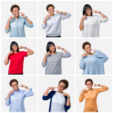 Kendinden emin gösterilen ve işaret parmakları diş ve ağız ile gülümseyen izole arka plan üzerinde afro saçlı genç Afro-Amerikan kadın. Sağlık kavramı.