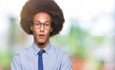 Genç Afro-Amerikalı iş adamı afro saçlı gözlüklü korkuyor ve sürpriz ifade, korku ve heyecan yüz ile şok.