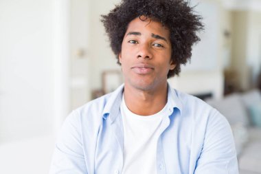 Yüzünde ciddi bir ifade ile Afrika kökenli Amerikalı adam evde rahat. Basit ve çapraz silah ile doğal